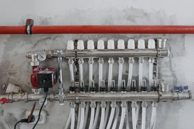 Installation de plomberie avec collecteur et circulateur : chauffe-eau en panne, réparer ou remplacer